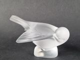 a glass bird that is sitting on top of a table