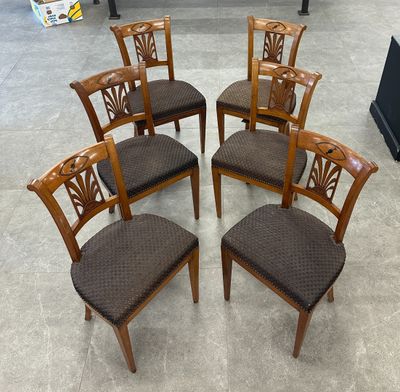six chaises en bois sont disposées en cercle sur le sol
