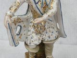 a figurine of a man with a hat and a bag
