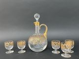 four glasses and a decanter sitting on a table