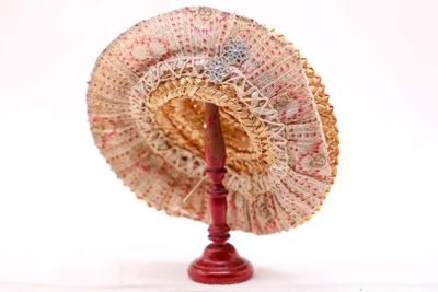 un support rouge sur lequel est posé un ventilateur, sur fond blanc