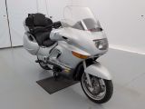 une moto blanche garée dans une pièce aux murs blancs