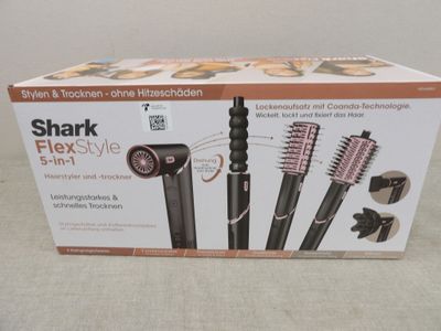 emballage d'une boîte contenant des brosses à cheveux et des peignes, posée sur une table