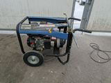an image of a portable generator on wheels in front of a garage