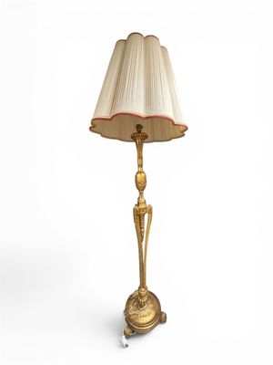 une image représentant une lampe dorée surmontée d'un abat-jour blanc