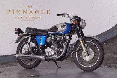 a blue motorcycle parked in front of a white wall