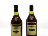 deux bouteilles de vin posées l'une à côté de l'autre sur une surface blanche