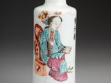 a white vase with a painting of a woman sitting on a chair
