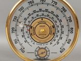 une horloge dorée et blanche posée sur un socle noir