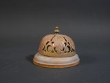 a small bell on top of a table on a black background