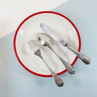 a red and white plate with silverware on it