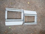 a broken window frame on the ground next to the ground