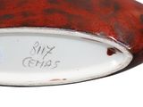 a close up of a red and white plate with writing on it