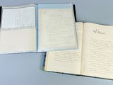 two open notebooks with writing on them sitting on a table