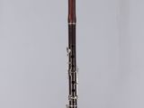 a close up of a clarinet in a clear case on a white surface