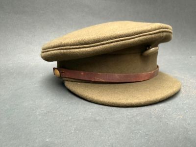 bonnet en laine beige orné d'un bandeau en cuir sur le dessus