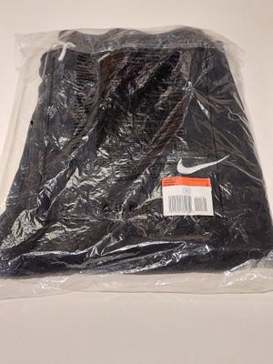 a black shirt wrapped in plastic on a white surface