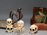 a group of skeleton figurines sitting next to a picture