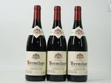 trois bouteilles de vin rouge posées sur une table blanche