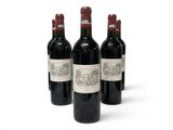 three bottles of red wine are lined up on a white surface