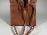 the small brown bag is sitting on a white surface