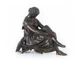 une image représentant une statue en bronze d'une femme assise sur une chaise