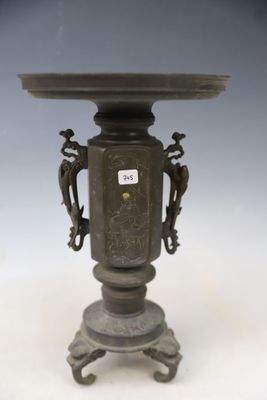 an antique bronze vase on a pedestal with two birds on it