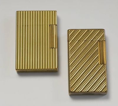 deux briquets dorés posés l'un à côté de l'autre sur une surface blanche