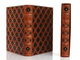 un vieux livre orné d'un motif décoratif sur la couverture et au dos
