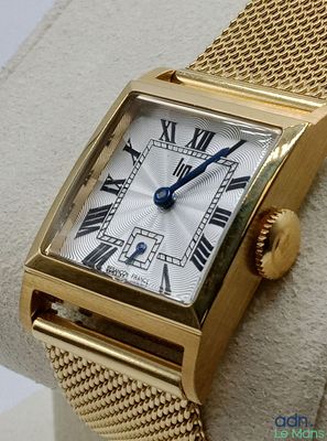 une image d'une montre-bracelet en or avec des chiffres romains