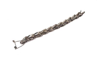 a close up of a metal bracelet on a white surface