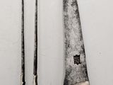 two knives are sitting next to each other on a white surface