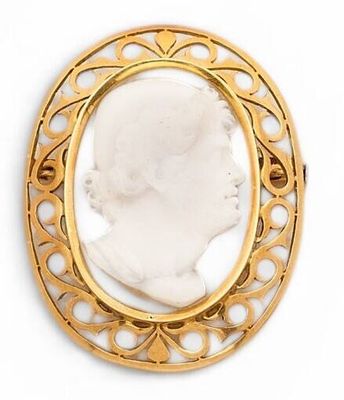 an antique gold broochle with a white stone in the center