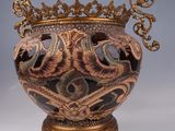 a vase that has a crown on top of it