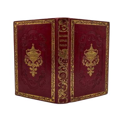 a red book with gold trimming and ornate design on the cover