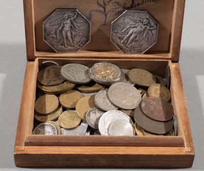 a wooden box filled with coins on a table