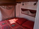 a bed with a red comforter in a small room
