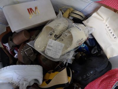 many pairs of shoes in a bag on the floor