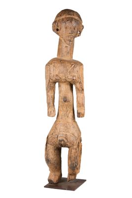 une statue en bois d'un homme avec un chapeau sur la tête
