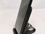 a cell phone that is on a stand on the table