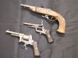 three old guns are sitting on a black cloth on a table