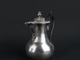 an antique silver coffee pot on a black background with a black background