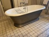 une baignoire au milieu d'un sol carrelé dans une salle de bains