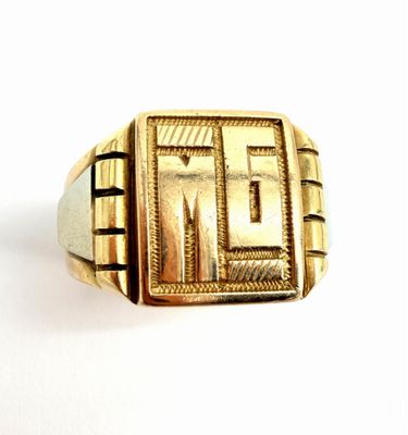 une image d'un gros plan d'une bague en or sur une surface blanche