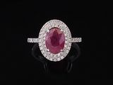 an oval ruby and diamond ring on a black background