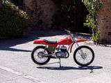 a red dirt bike parked on the side of the road