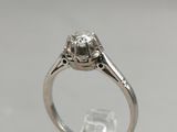 a close up of a diamond ring on a clear surface