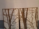 deux photos encadrées représentant des arbres posées sur un sol bleu