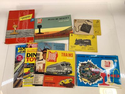 de nombreux livres posés sur une table, avec un train en arrière-plan