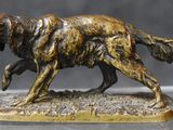 statue of a golden retriever dog running on a gray surface